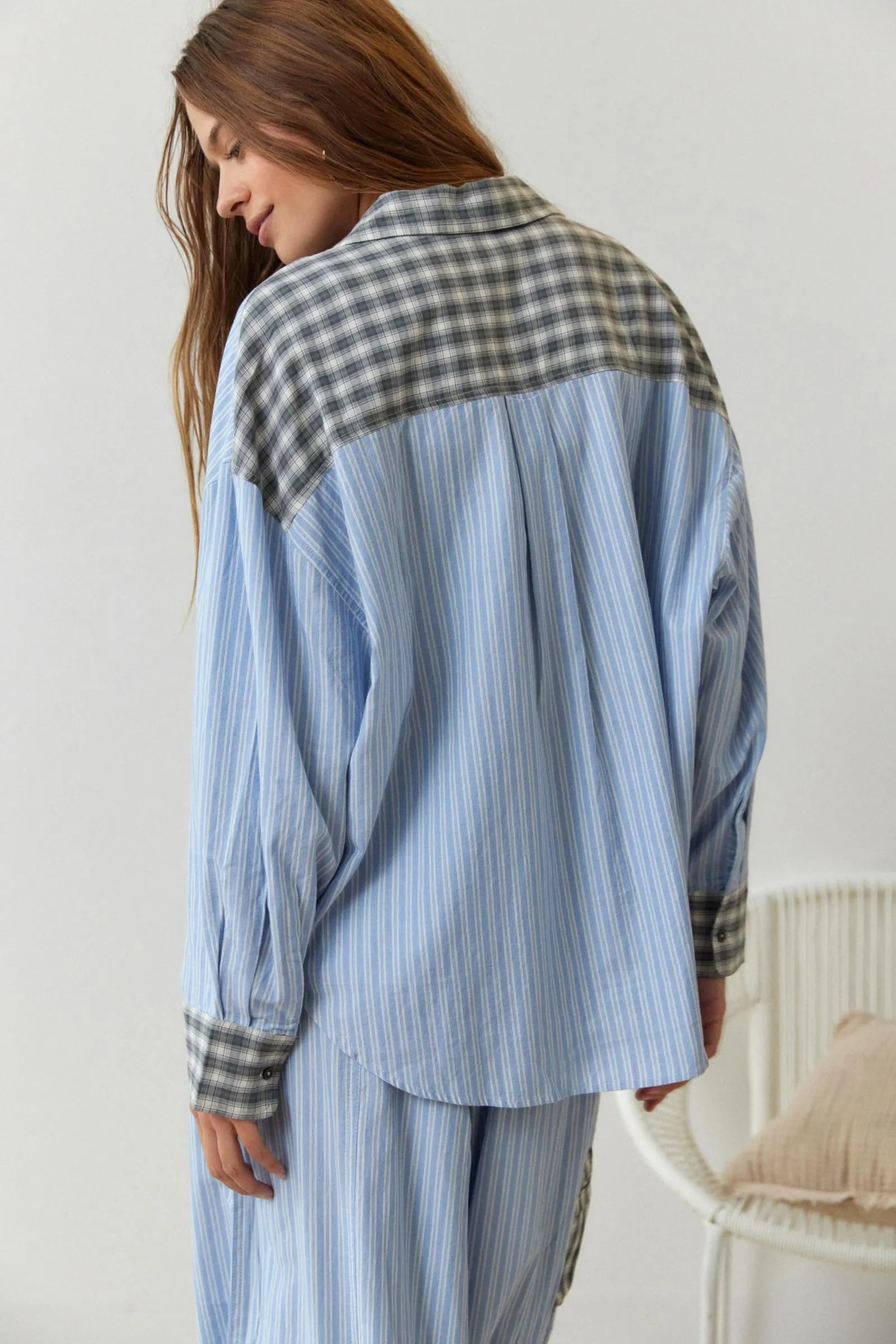 En kvinne har på seg et 2-delt, uformelt pyjamassett med rutemønster