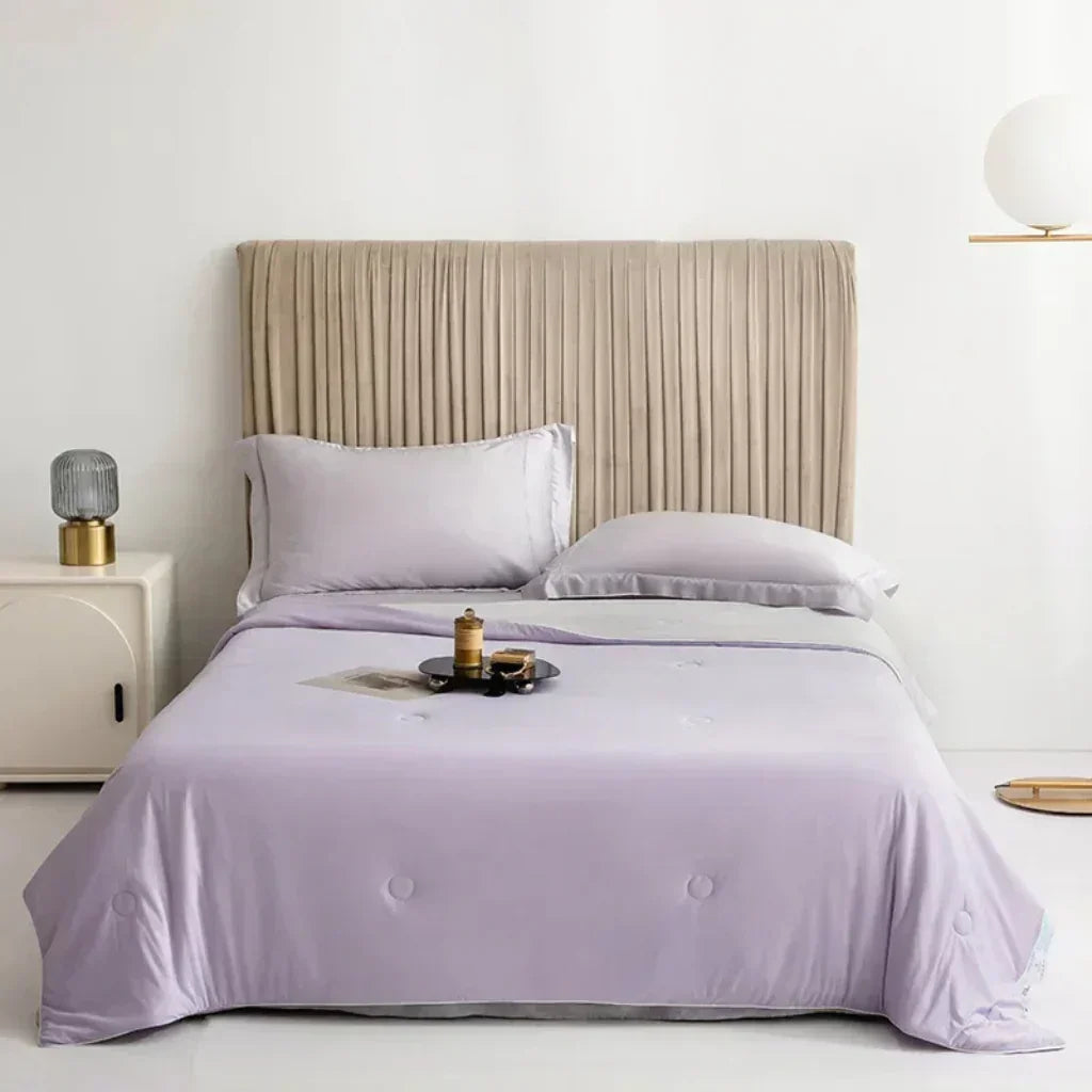 "Kühlende Sommerdecke in Himmelblau auf Bett, ideal für heiße Nächte, atmungsaktiv und hautfreundlich für erholsamen Schlaf."