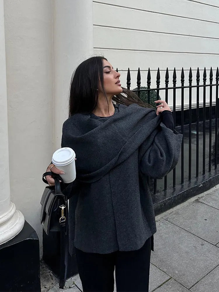 Moderner grauer Cape-Mantel für Frauen, eleganter Schnitt, dekorative Knöpfe, fließender Stoff, stilvoller Look.