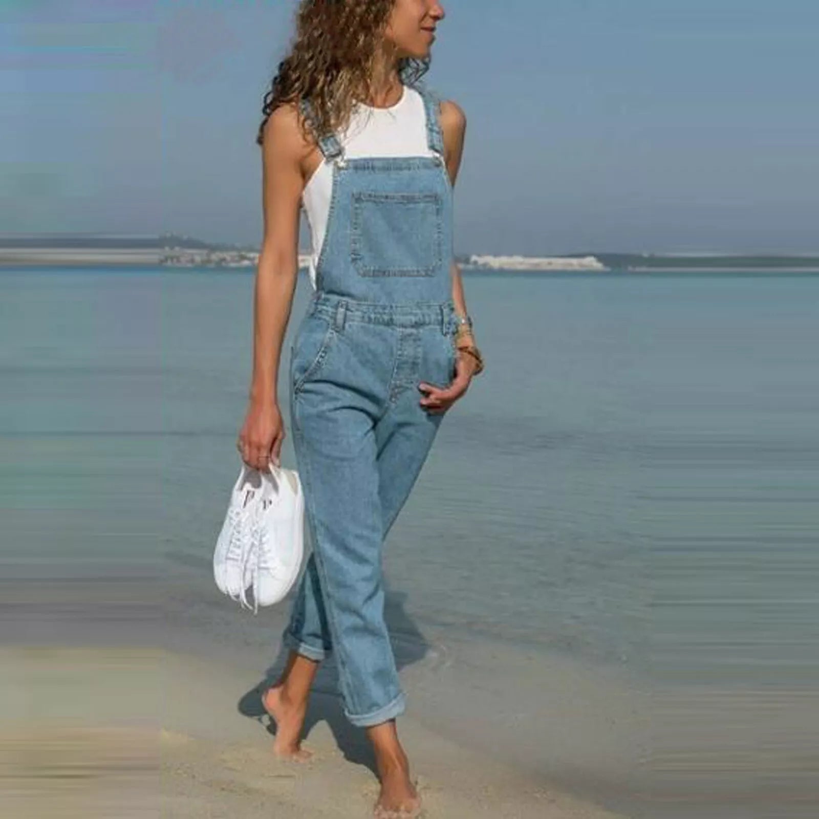 "Stilvolle Denim-Latzhose für Damen, vorne gesehen, mit anpassbaren Trägern und praktischen Taschen."