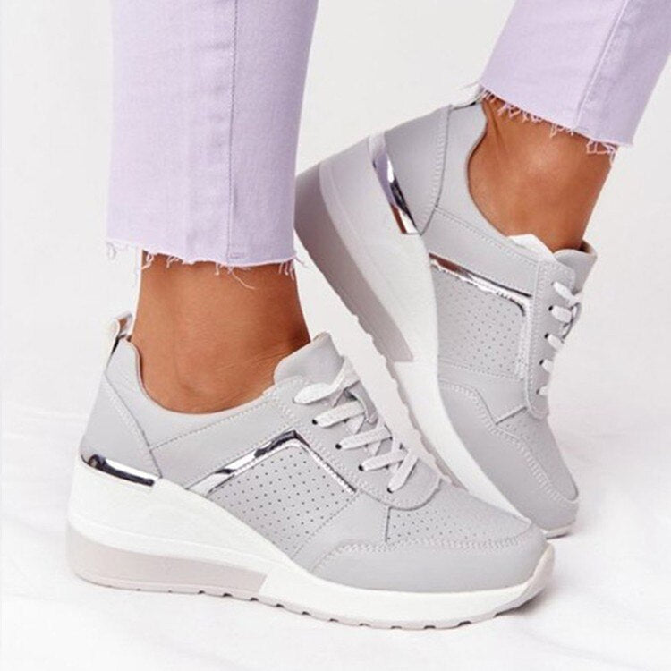 "Weiß orthopädische Damenschuhe, komfortabel, modisch, getragen von sitzender Person mit hellen Hosen"