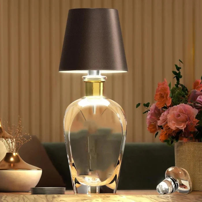Hvit bærbar LED-lampe på et nattbord, gir varmt, dimbart lys med enkel touch-kontroll.