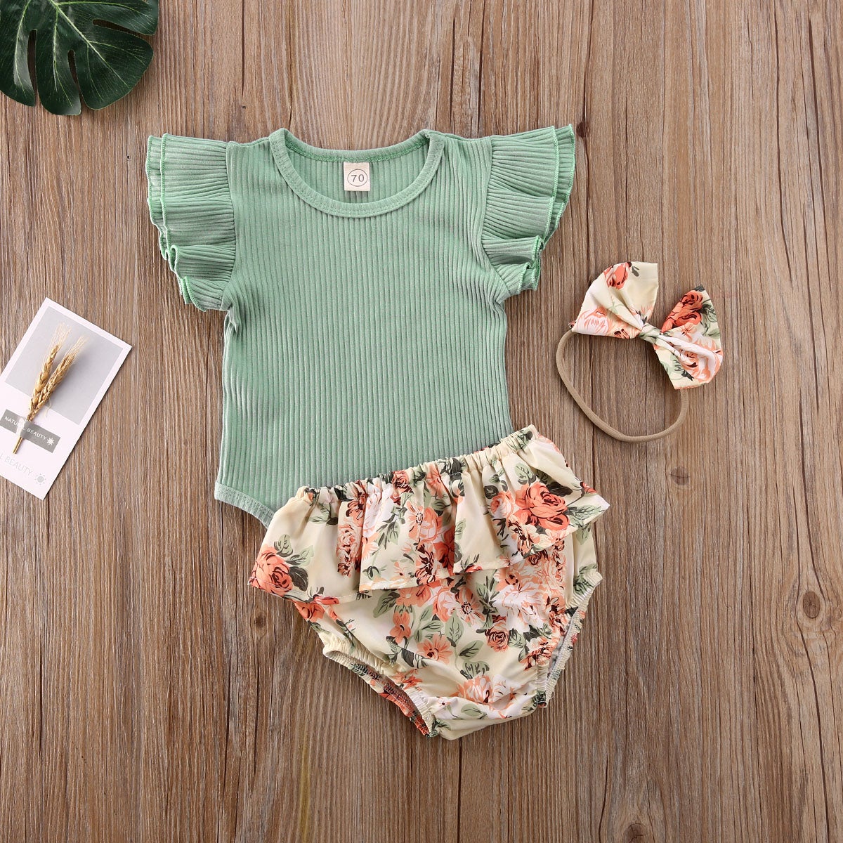 Heldekkende bilde av baby jentesett i blomsterprint, perfekt for sommer