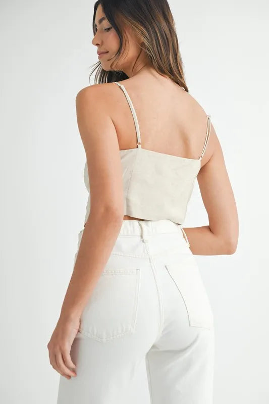 Stilfull dame tank topp i beige med knappedetaljer. Kort lengde, ideell for sommerens hverdagsantrekk.