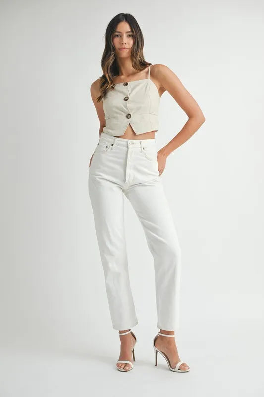 Modell iført beige kort tank topp med knapper. Flatterende snitt, ideell for sommerens trendsettende dame.
