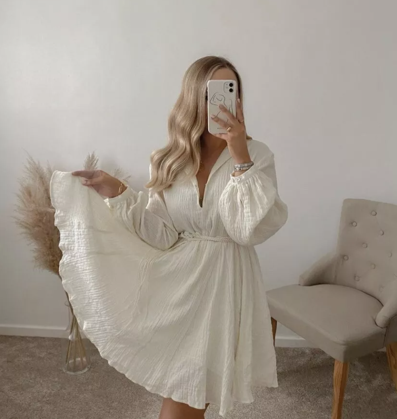 Komfortabel beige damekjole med flatterende V-hals, trendy ballongermer og justerbart belte.
