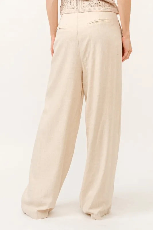 Elegant antrekk med beige vide damebukser med høyt liv, stilige og komfortable for kvinner.