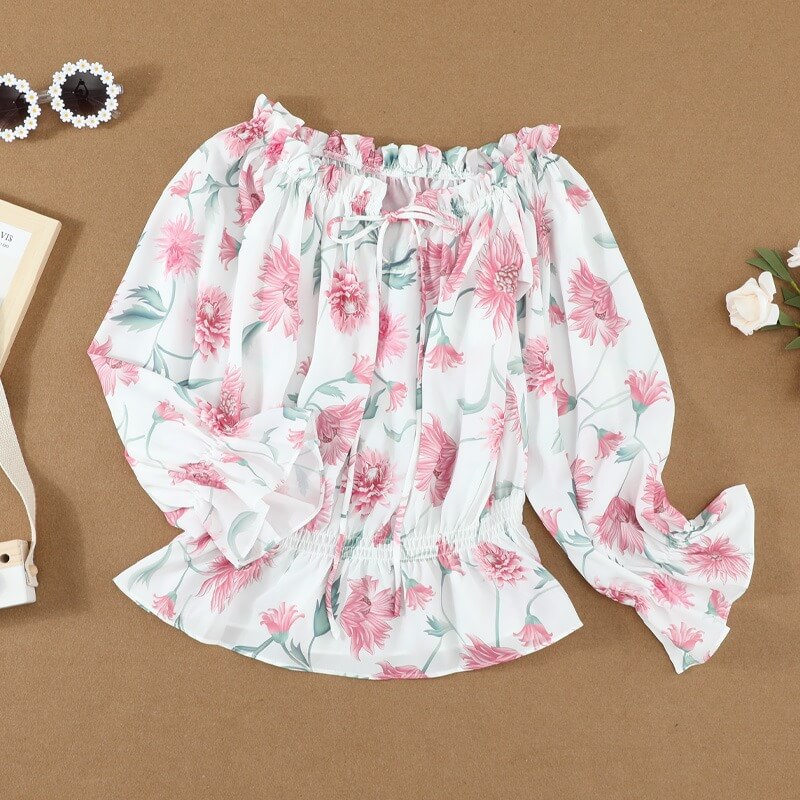 Festtopp/fritidsbluse for dame, blomstret med volanger, elegant og lett. Perfekt for sommerdager.