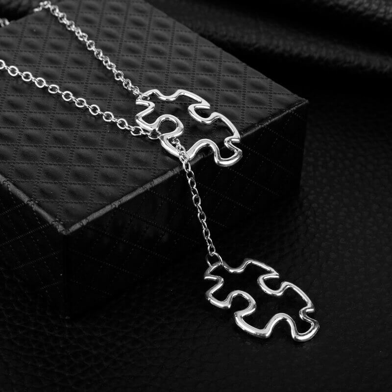 Detalj av puslespillanheng på damehalskjede, symboliserer autisme bevissthet og solidaritet. Elegant smykke.