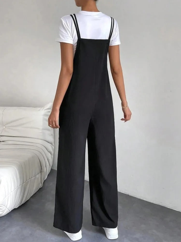 Dame modell viser komfortabel jumpsuit med seler og elegant vid benpassform, perfekt for fritid og stil.