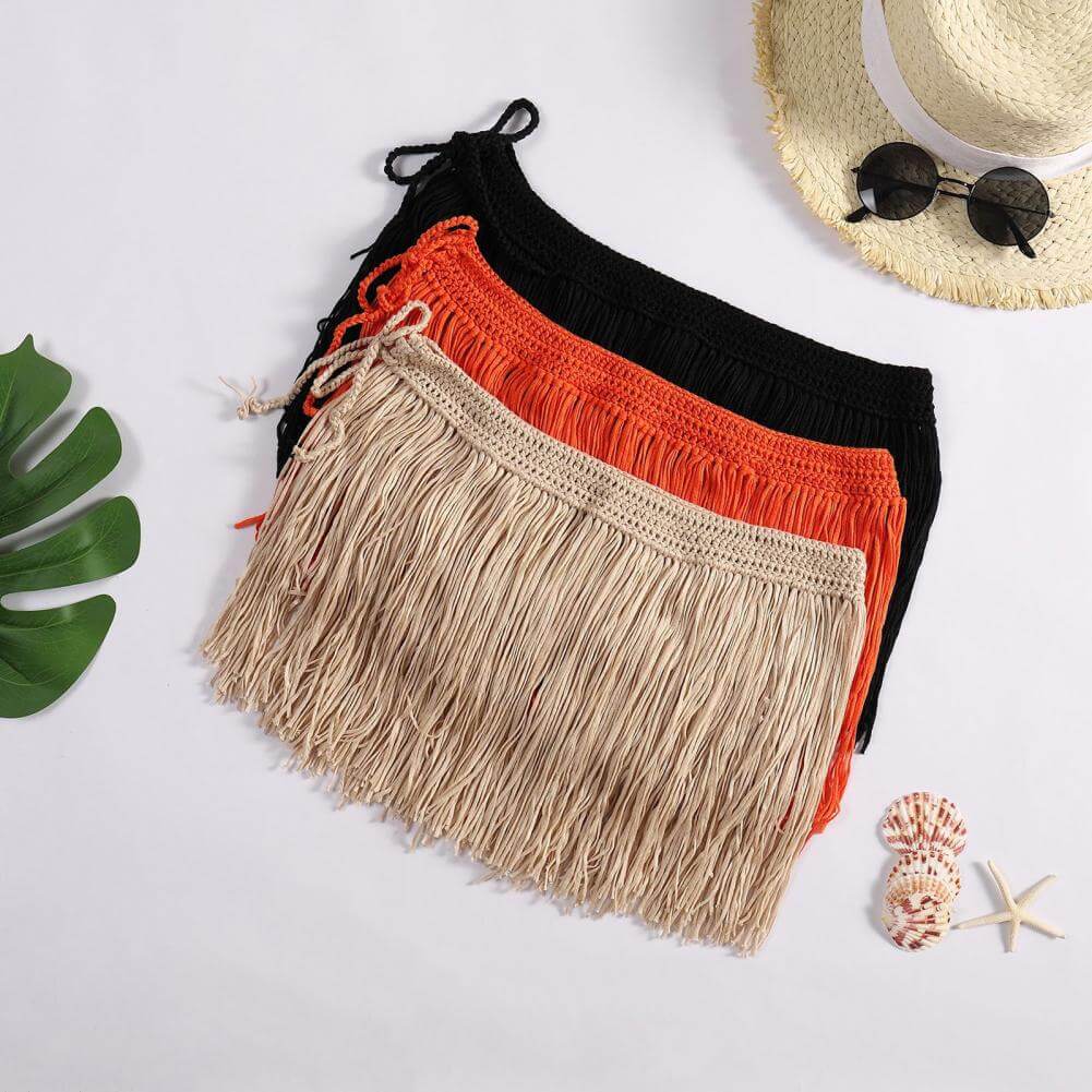 Sommerlig dameskjørt med knyting og lekre dusker, stilig accessoir til badetøy.