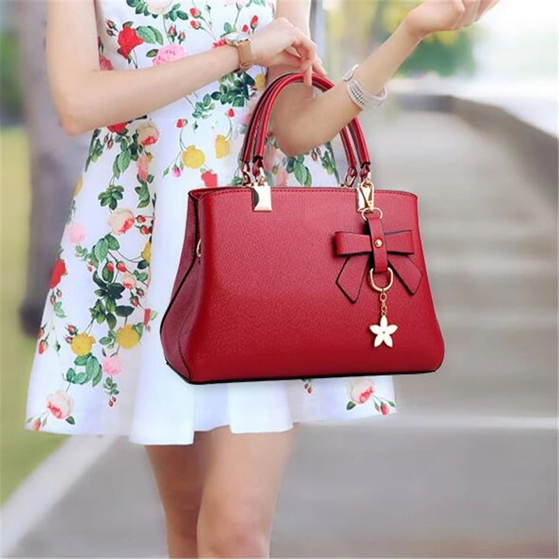 Dame crossbody-veske med moderne snitt og delikat blomsterpynt. Et must-have tilbehør.