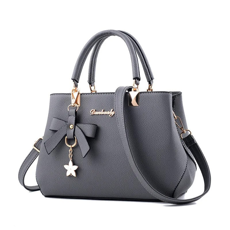 Stilig crossbody-veske for dame, dekorert med delikate blomster. Perfekt skulderveske.