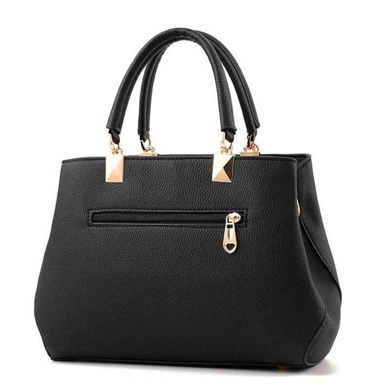 Dameveske med justerbar stropp, bærekomfort som skulderveske eller crossbody. Blomsterdetalj.