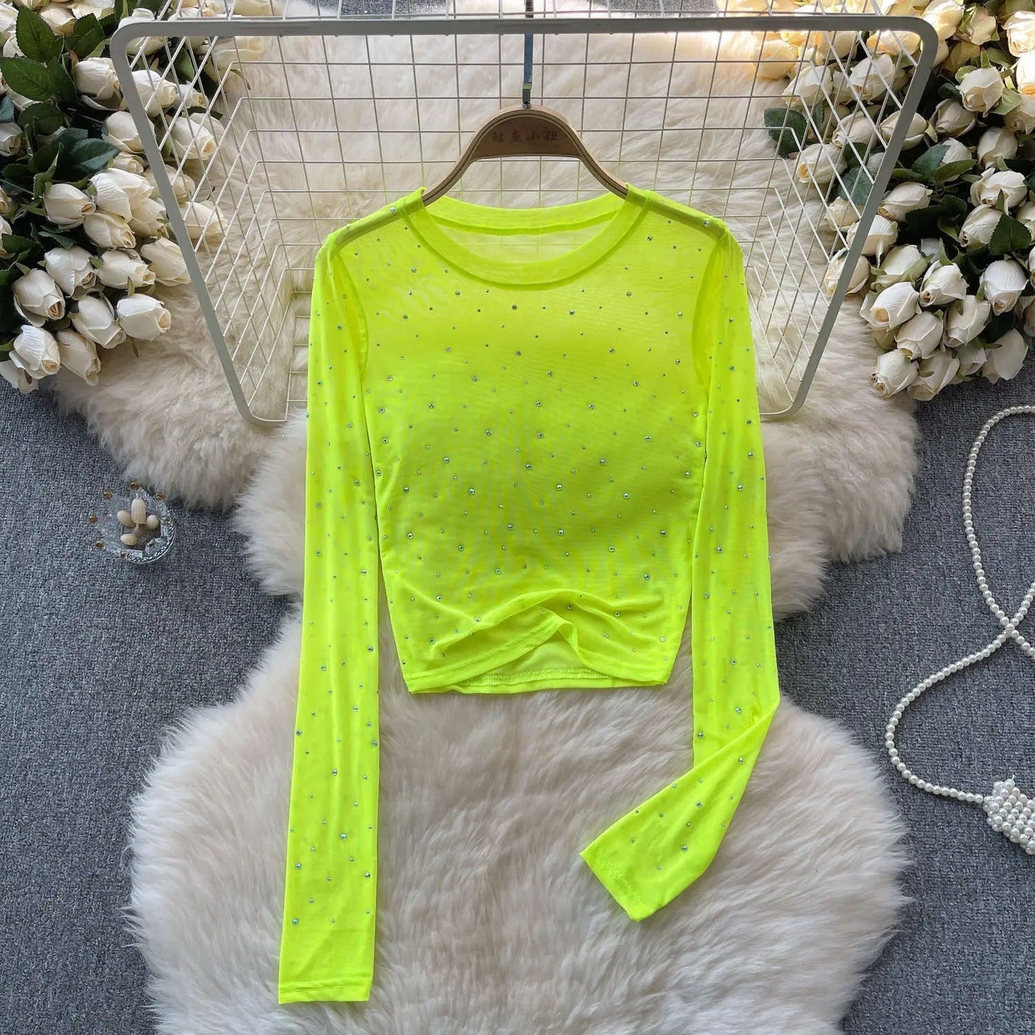 Slimfit dame crop top med rhinestones. Komfortabel og stilfull langermet glittertopp for fest og mote.