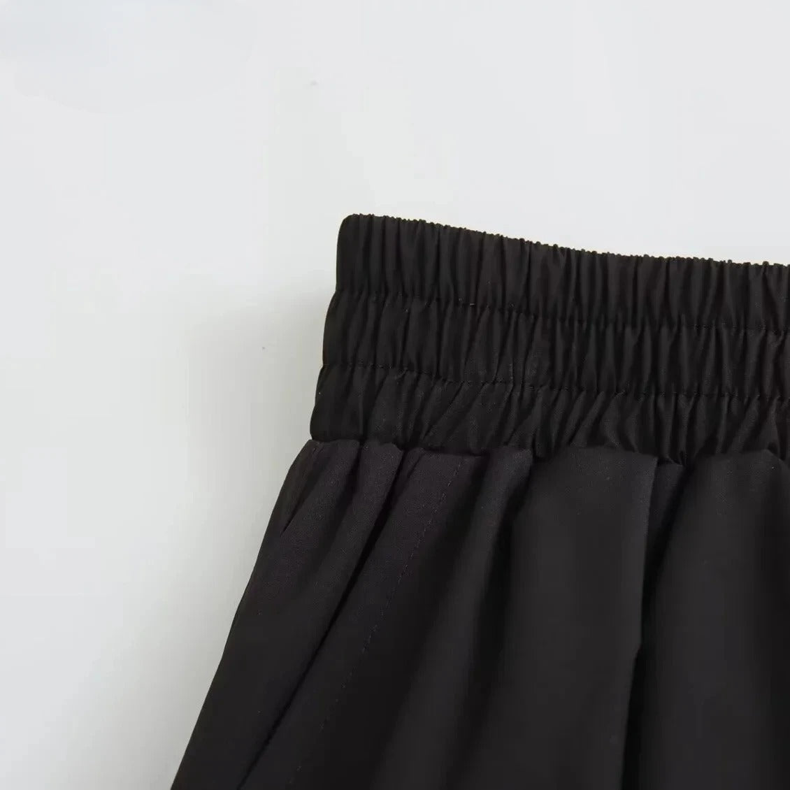 Allsidig svart A-linje plissert dameskjørt, stylet for en moderne og chic look.