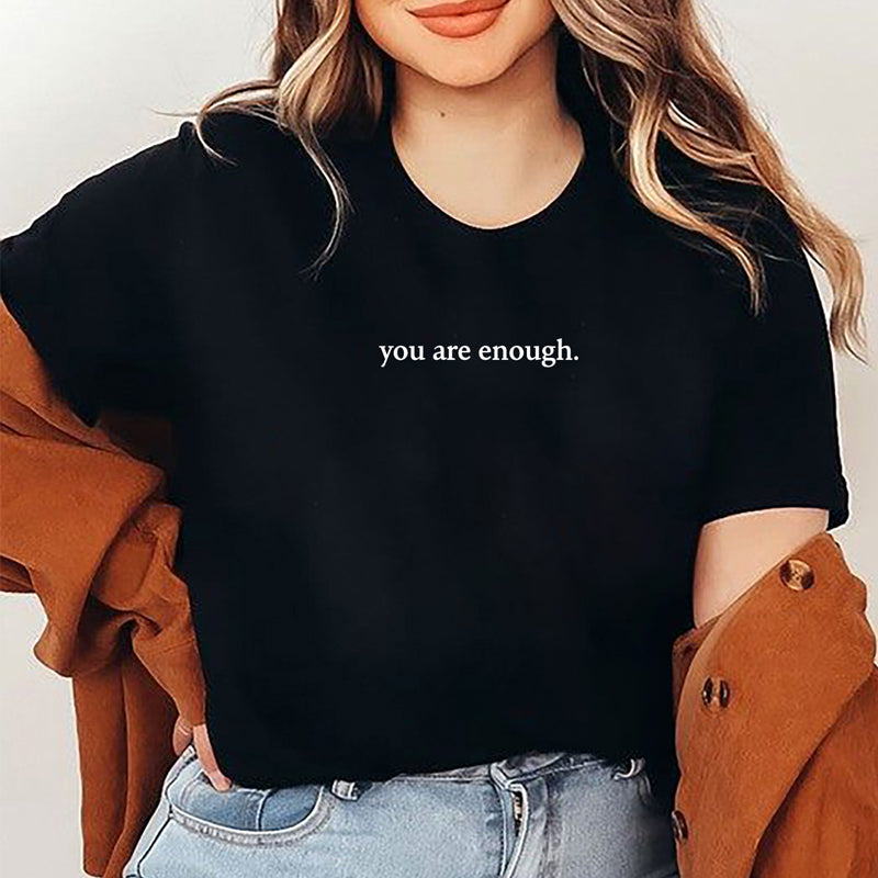 Nærbilde av dame T-skjorte med skrifttypen for 'You are Enough' motivet. Inspirerende mote.