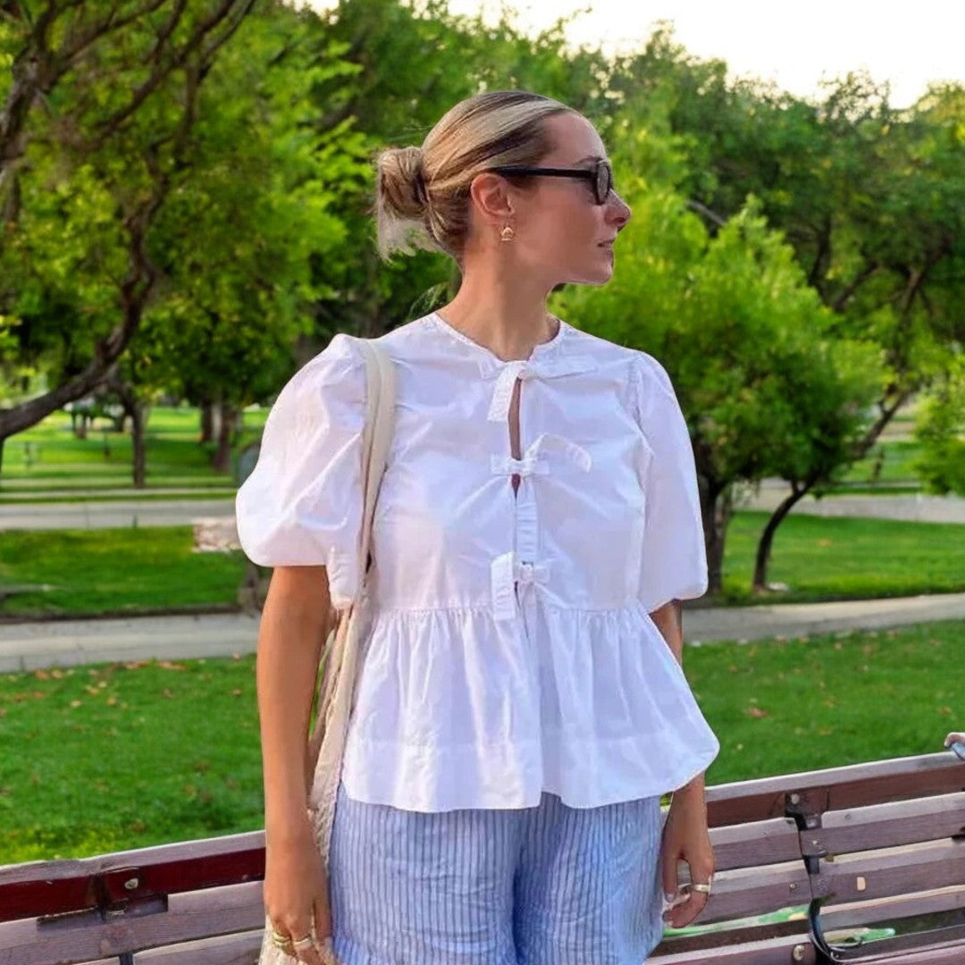 Elegant damebluse med feminine puffermer og snøring i halsen. En moteriktig sommerbluse.