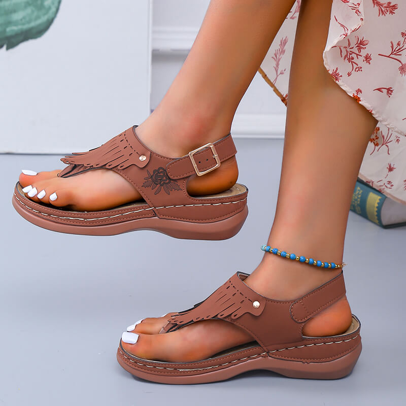 Damesandaler med kilehæl sett forfra. Fokus på de livlige duskene og behagelig design.