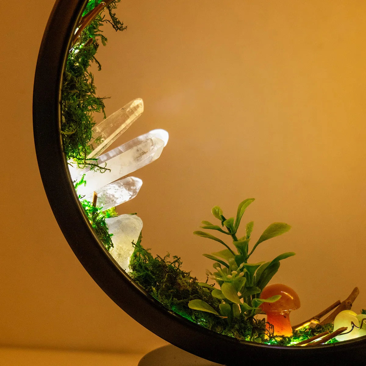 Minimalistisk bordlampe med sirkulær ramme, grønne planter og et beroligende nattlys.