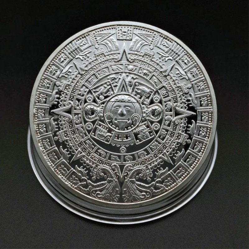 Nærbilde av detaljrik aztekisk kalender i gullfarget metall, veggpynt.