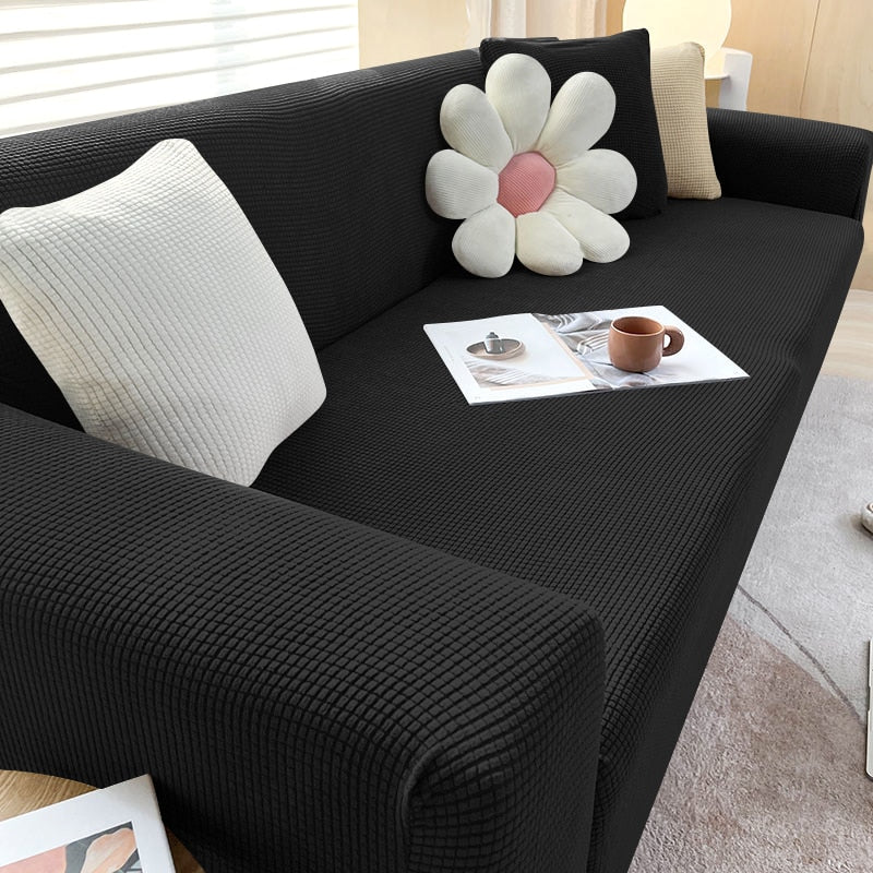 Mykt, elastisk sofatrekk i grått som tilpasser seg sofaens form for en perfekt og komfortabel passform.