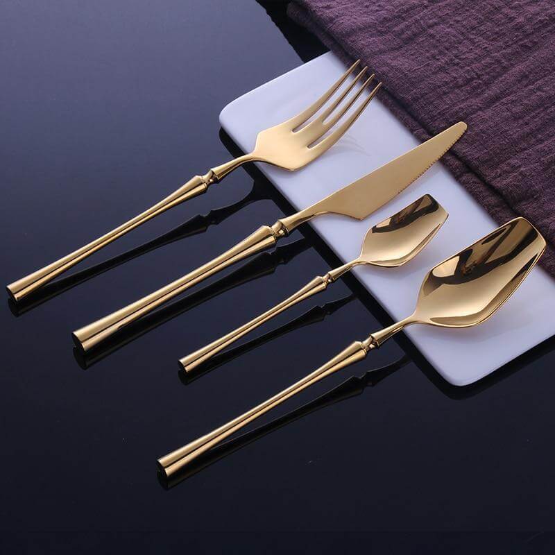 Vakkert spisebestikk i rustfritt stål, moderne design med gull, for en elegant middag.