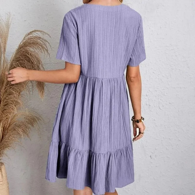 Nærbilde av stoffet på den flatterende Dame Peplum V-hals kjolen. Elegant volang design.