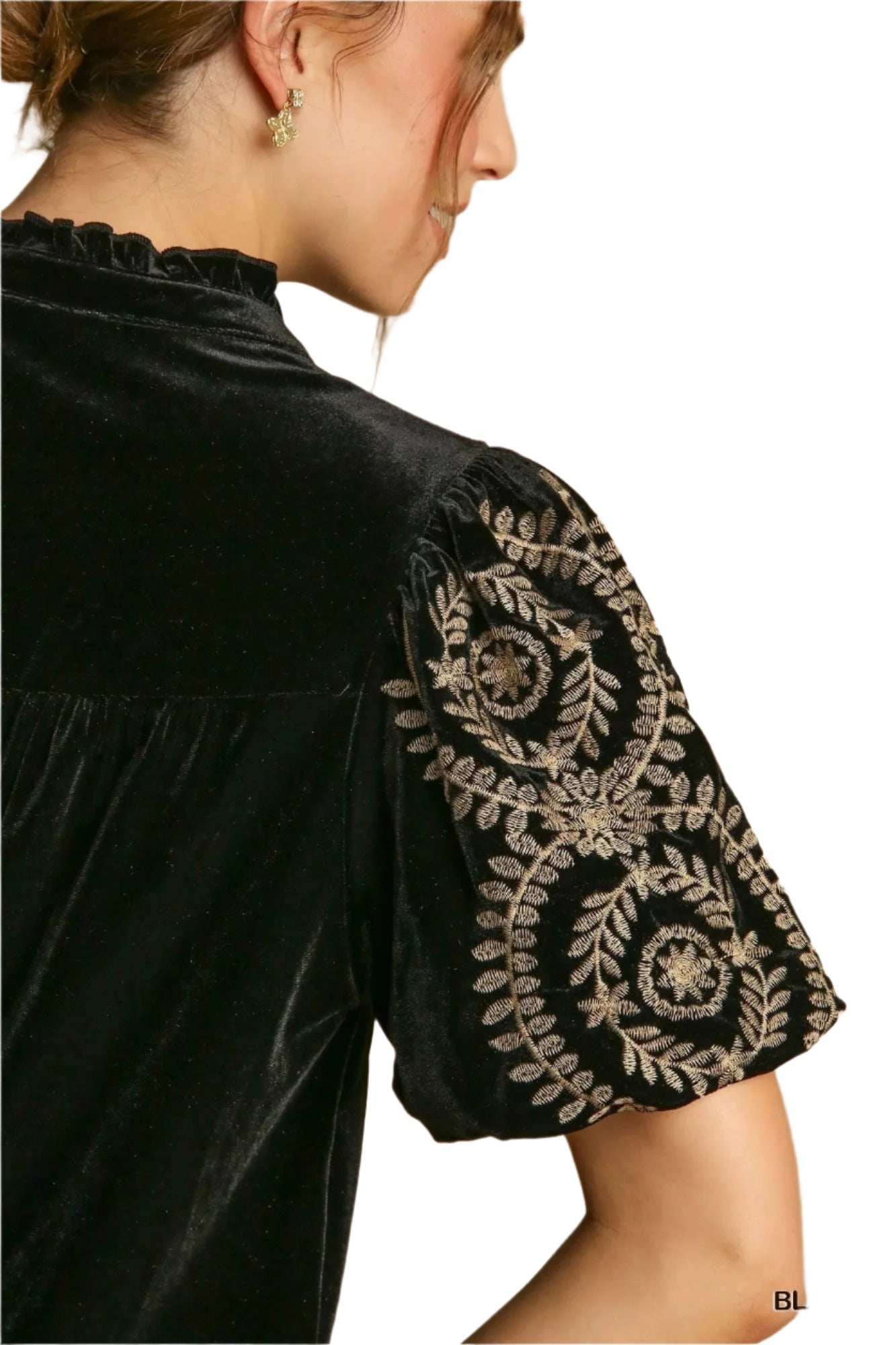 Detaljert bilde av damebluse med intrikate broderier på ermene. Stilig, moteriktig og elegant topp.