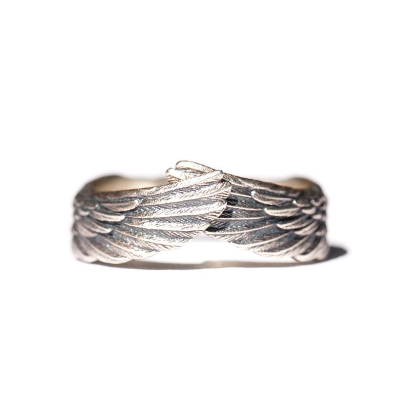 Nærvisning av polert sterlingsølv englevinge ring, delikat design for moderne kvinner.