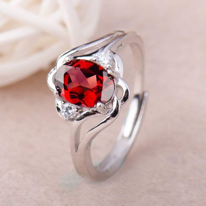 Nærbilde av elegant fødselssteinring for kvinner, glitrende cubic zirconia i sølvdesign.