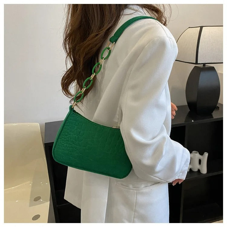 Dame med elegant svart filt armhuleveske på skulderen. Stilren og minimalistisk skulderveske for mote.