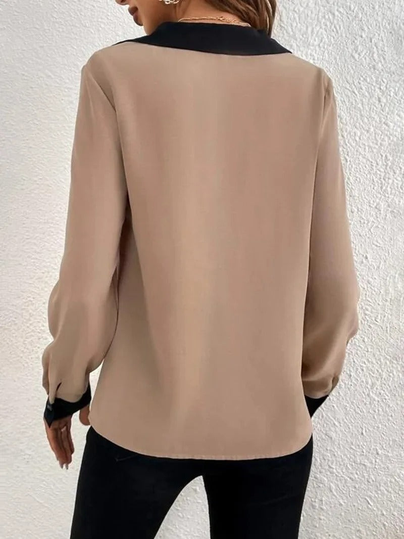 Nærbilde av detaljer på elegant langermet kontorbluse til dame, fokus på krage og stoff.