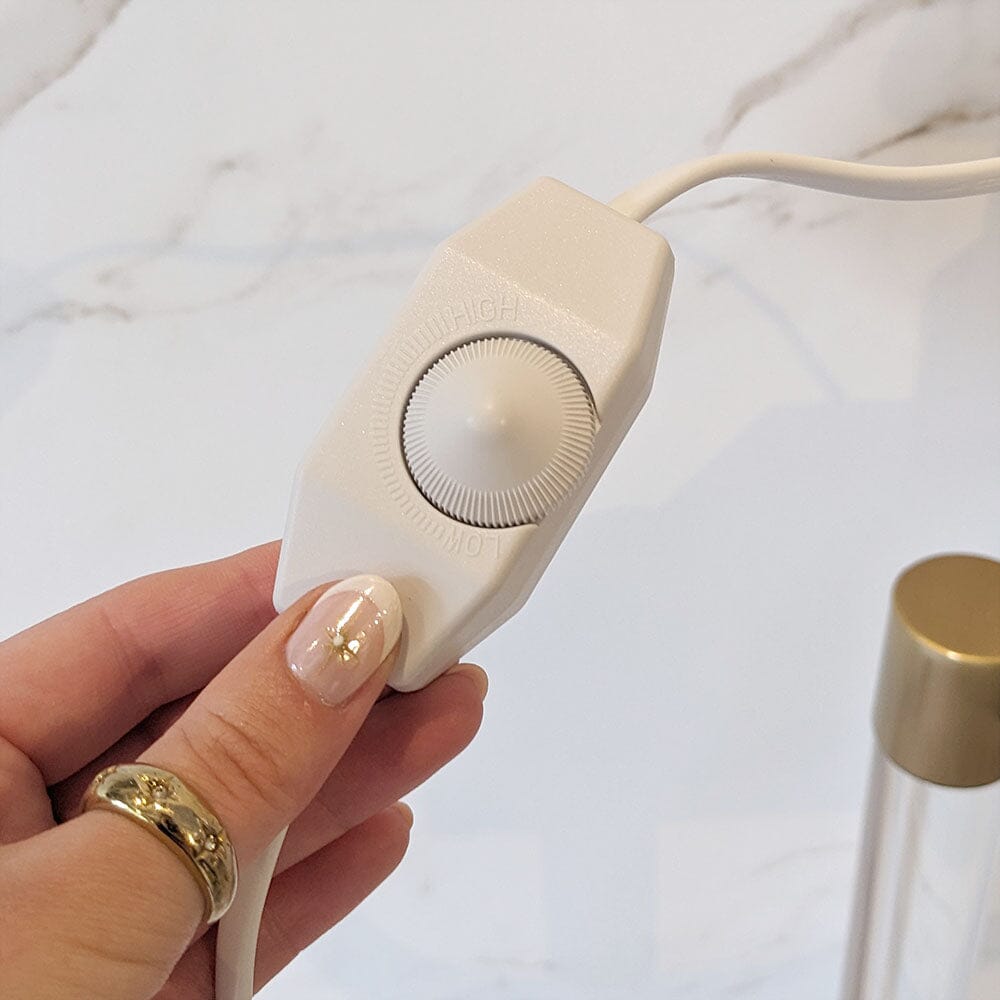 Luksuriøs lysvarmer i hvit og gull med minimalistisk design, et elegant tillegg til ethvert rom.