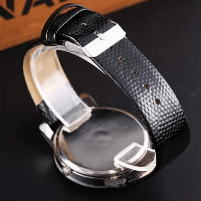 Skinnklokke for menn, kvarts, med mørk dress. Elegant armbåndsur som komplementerer formell stil.