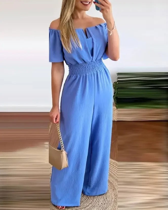Elegant off-shoulder jumpsuit for fest. Pyntet med tilbehør, vide ben for sofistikert look.