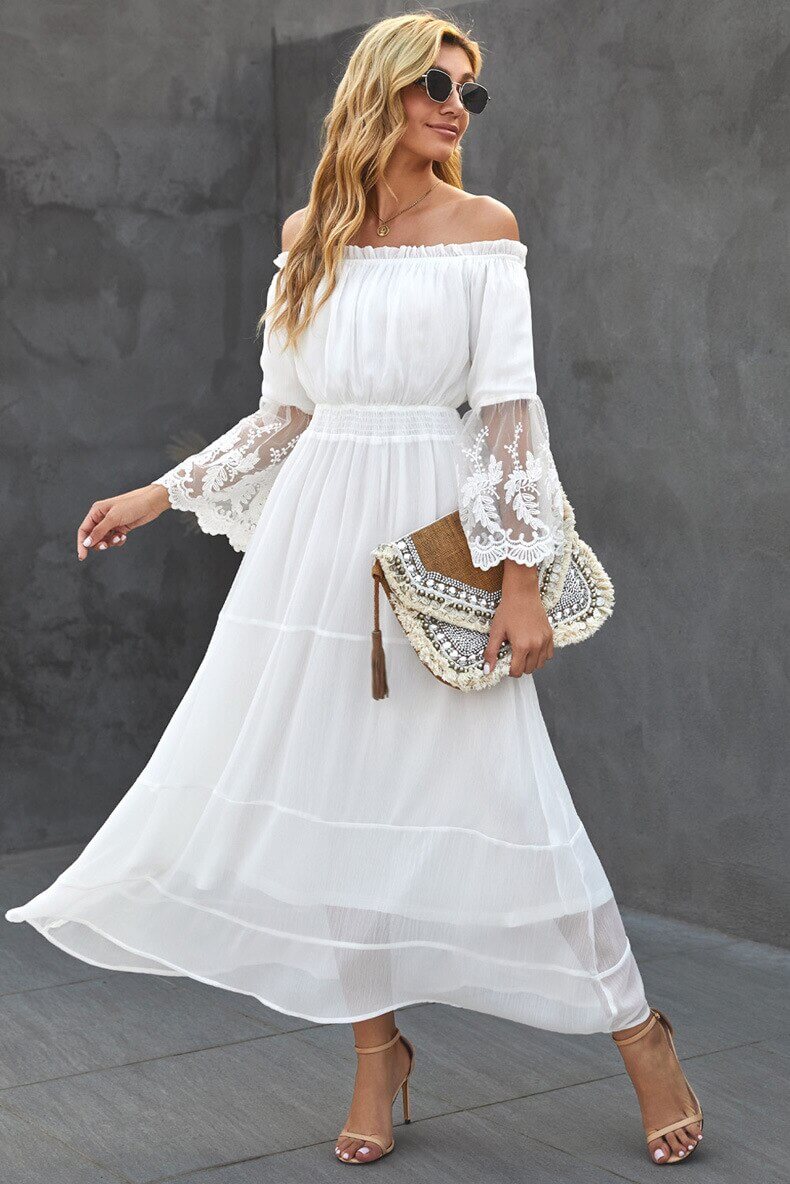 Dame i elegant lang blondekjole med offshoulder. Perfekt sommer- og festkjole.