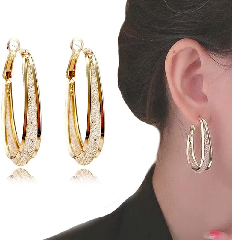 Nærbilde av glitrende ovale bøyleøreringer med zirconia, elegant kvinnesmykke og tilbehør.