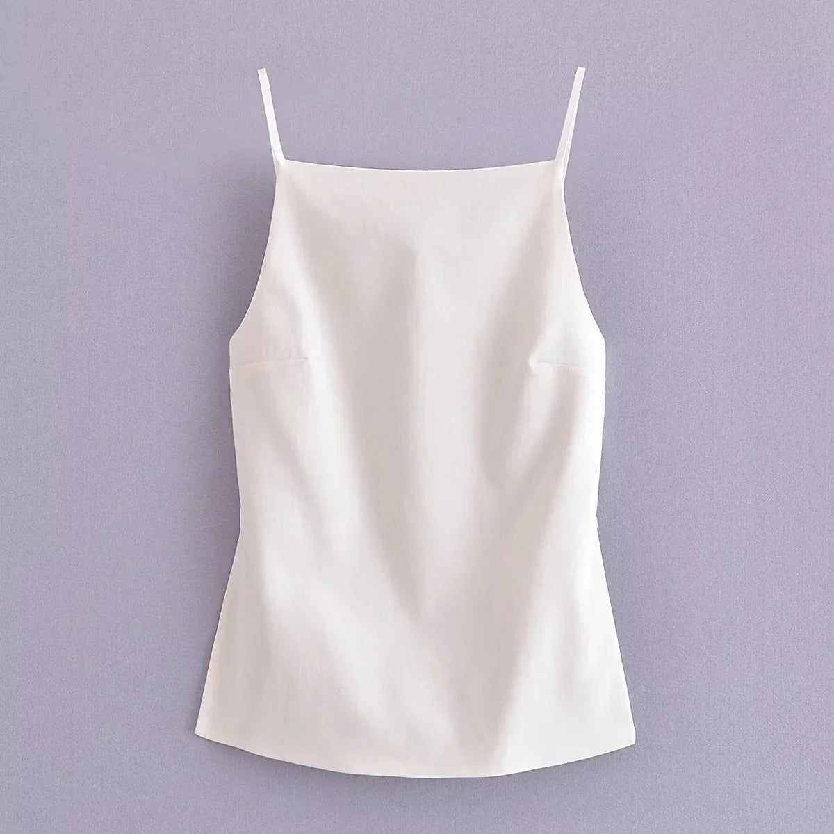 Trendy kvinner crop top med tynne stropper og ryggløs design. Ideell festtopp for sommeren.