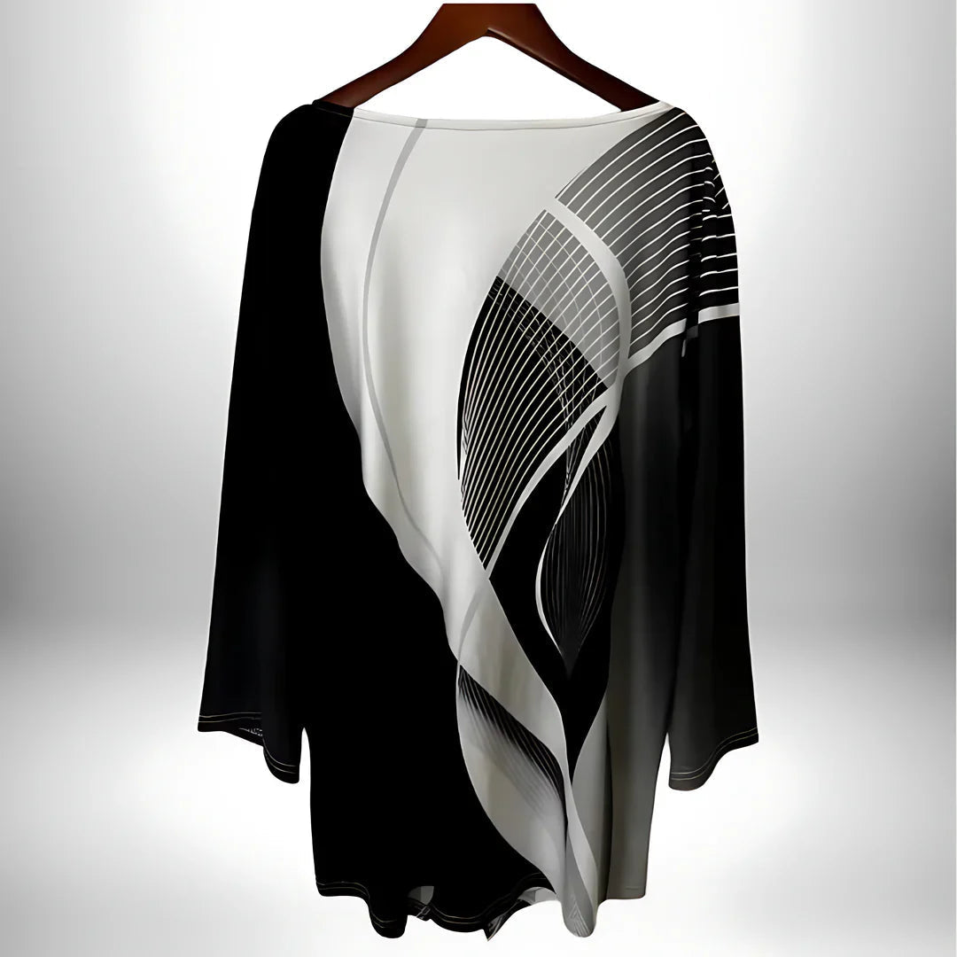 Stilig langermet dametopp med unikt geometrisk og asymmetrisk design, elegant i svart-hvitt.