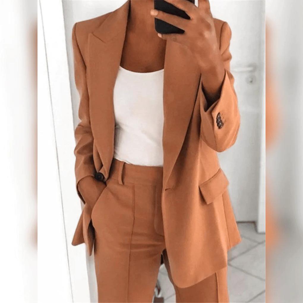 Nærbilde av elegant todelt dressett for dame, som viser stoff og detaljer på blazer og bukser.