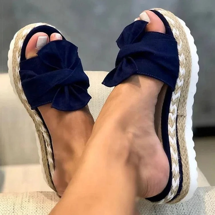 Damesandaler med kileplattformhæl, detalj av remmer. Komfortable sommersko med slip-on design.