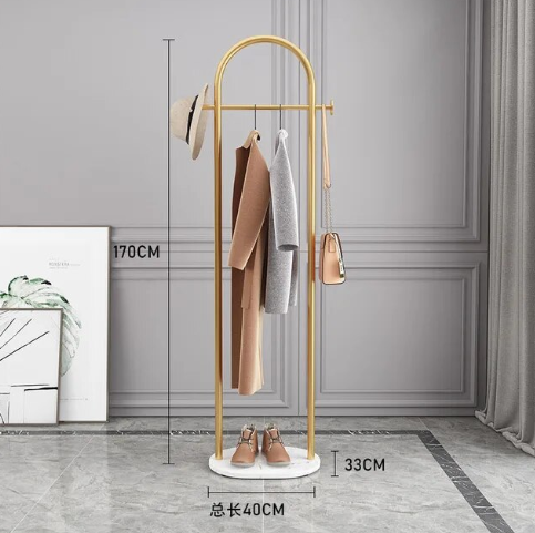 Frittstående klesstativ i gull med elegant marmorbase. Optimaliserer plass og legger til dekor.