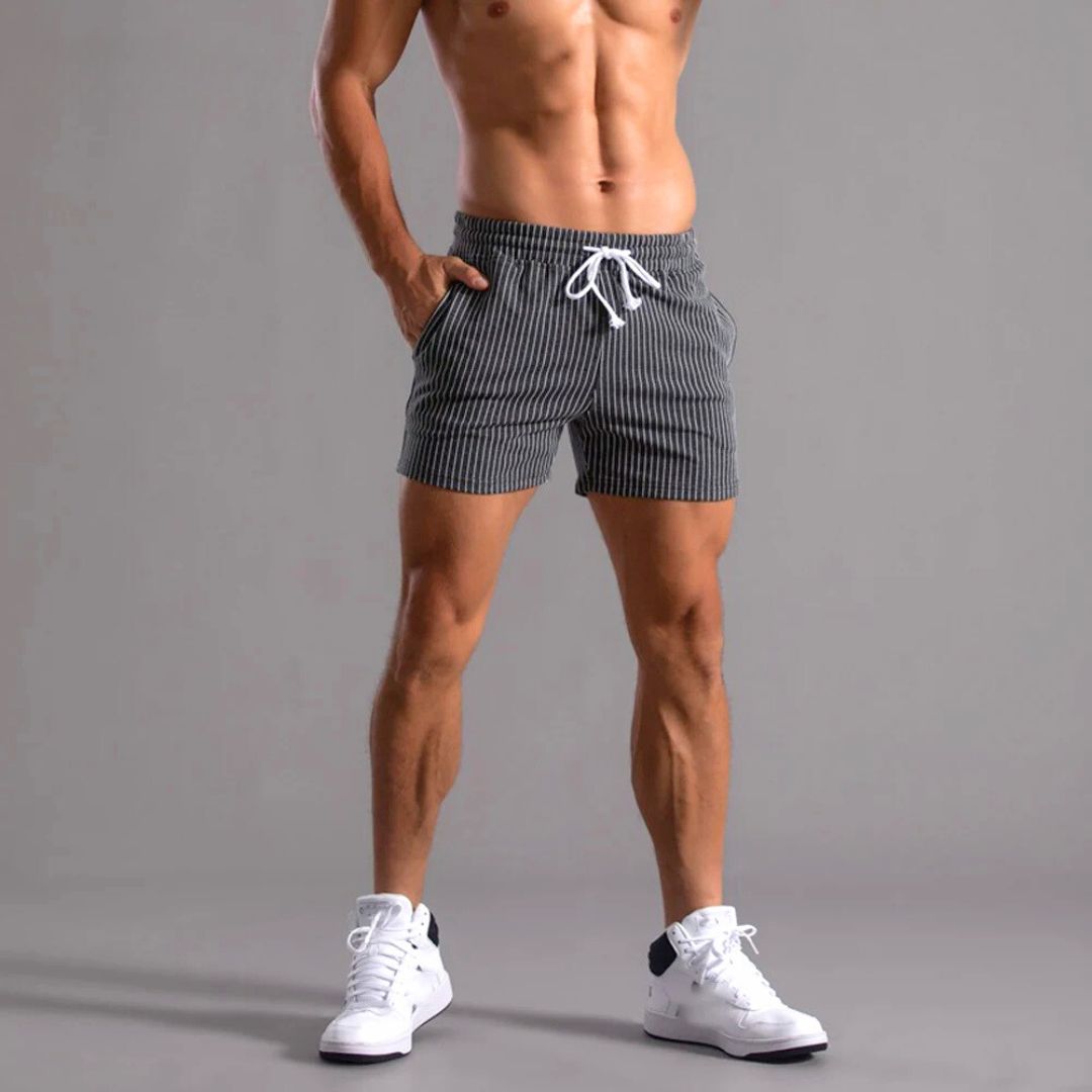 Komfortabel herre fritidsshorts med striper og elastisk midjebånd. Ideell for sommer og aktivitet. Athleisure look.