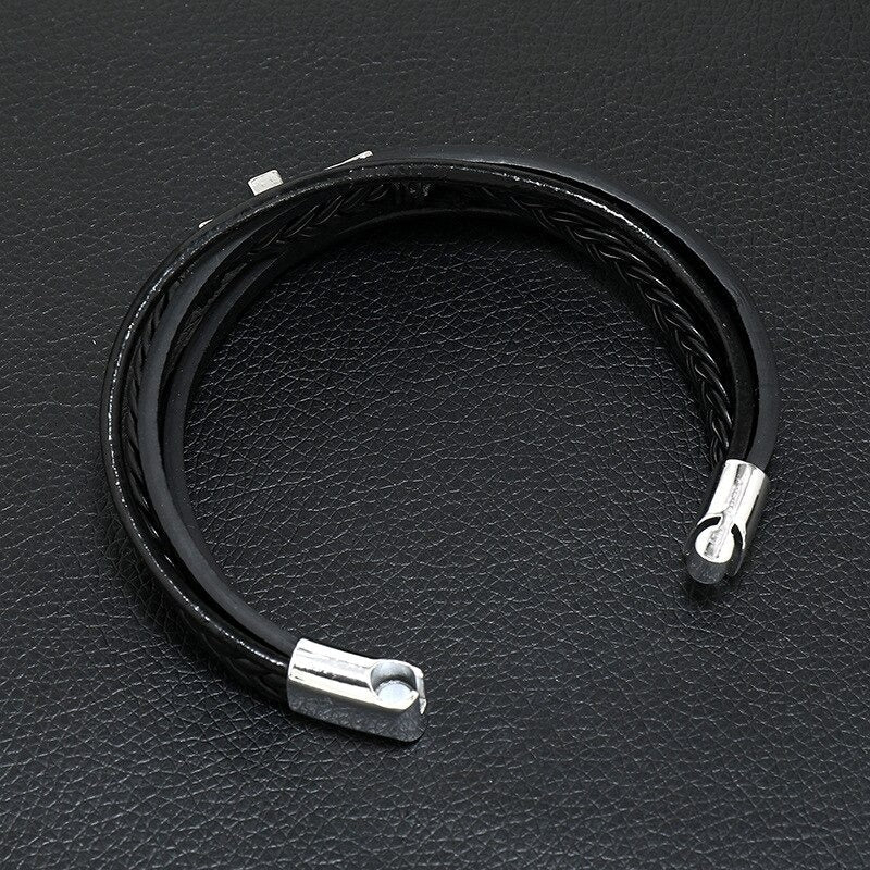 Elegant herrearmbånd i skinn med korsdesign og brukervennlig magnetlås. Et statement-smykke.