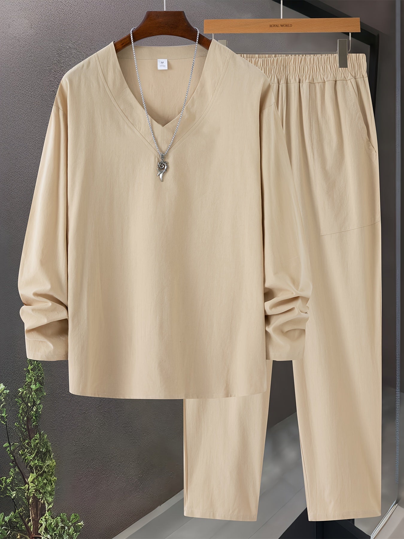 Herre loungewear sett med V-hals genser og bukser, pent brettet, viser frem det myke og komfortable stoffet.