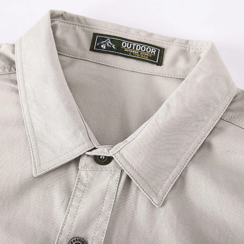 Detaljbilde av en robust herre cargoshirt med lange ermer i olivengrønn, praktiske cargolommer