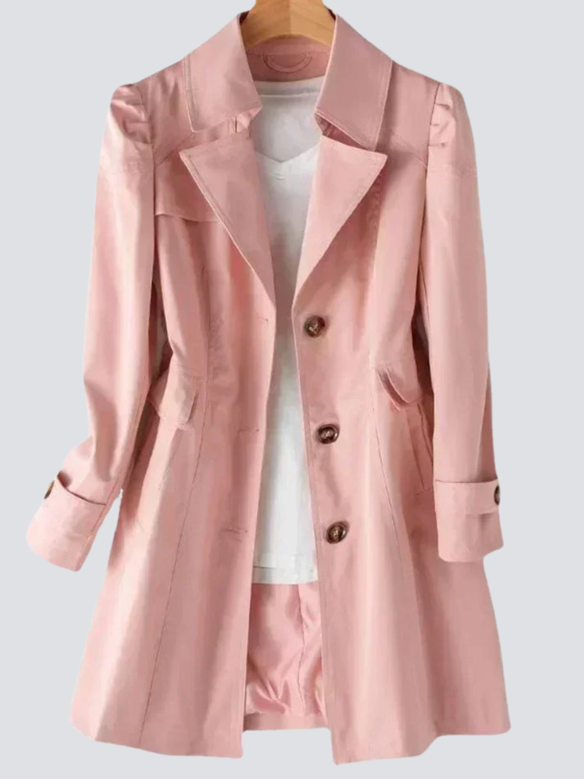 Detaljbilde av beige kvinners trenchcoat med belte. Fokus på stoff og tidløs design for elegant mote.