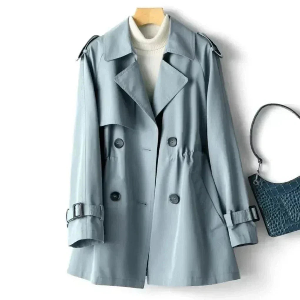 Stilren damekåpe, klassisk dobbeltradet trenchcoat, allsidig for både formelle og uformelle anledninger.