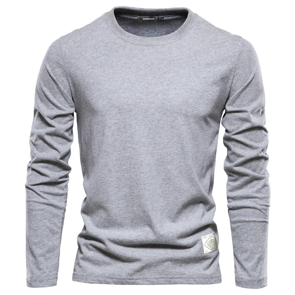 Allsidig ensfarget langermet t-skjorte for menn, ideell som basisplagg for casual look.
